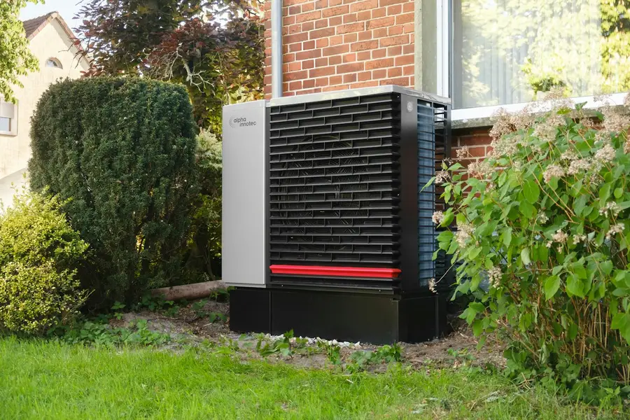 New heat pump installed beside a brick home