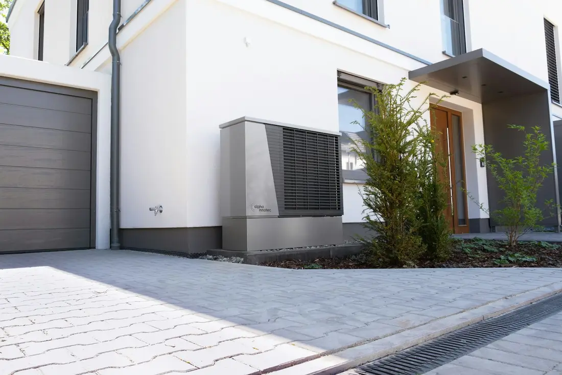 Modern home with an outdoor heat pump unit beside the entrance