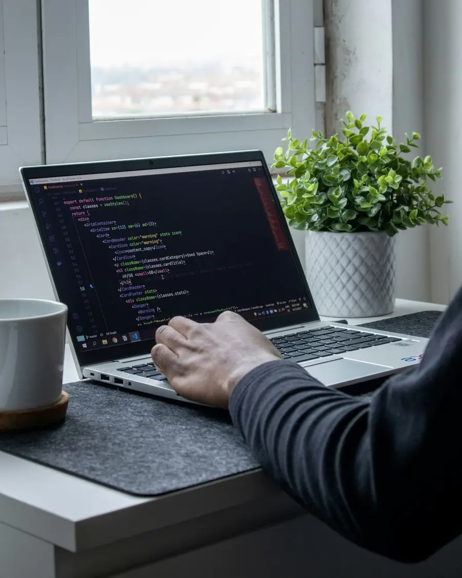 Developer writing code on a laptop at a desk