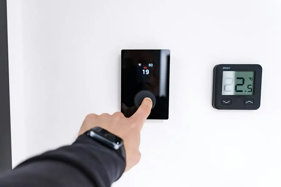 Homeowner adjusting a digital thermostat